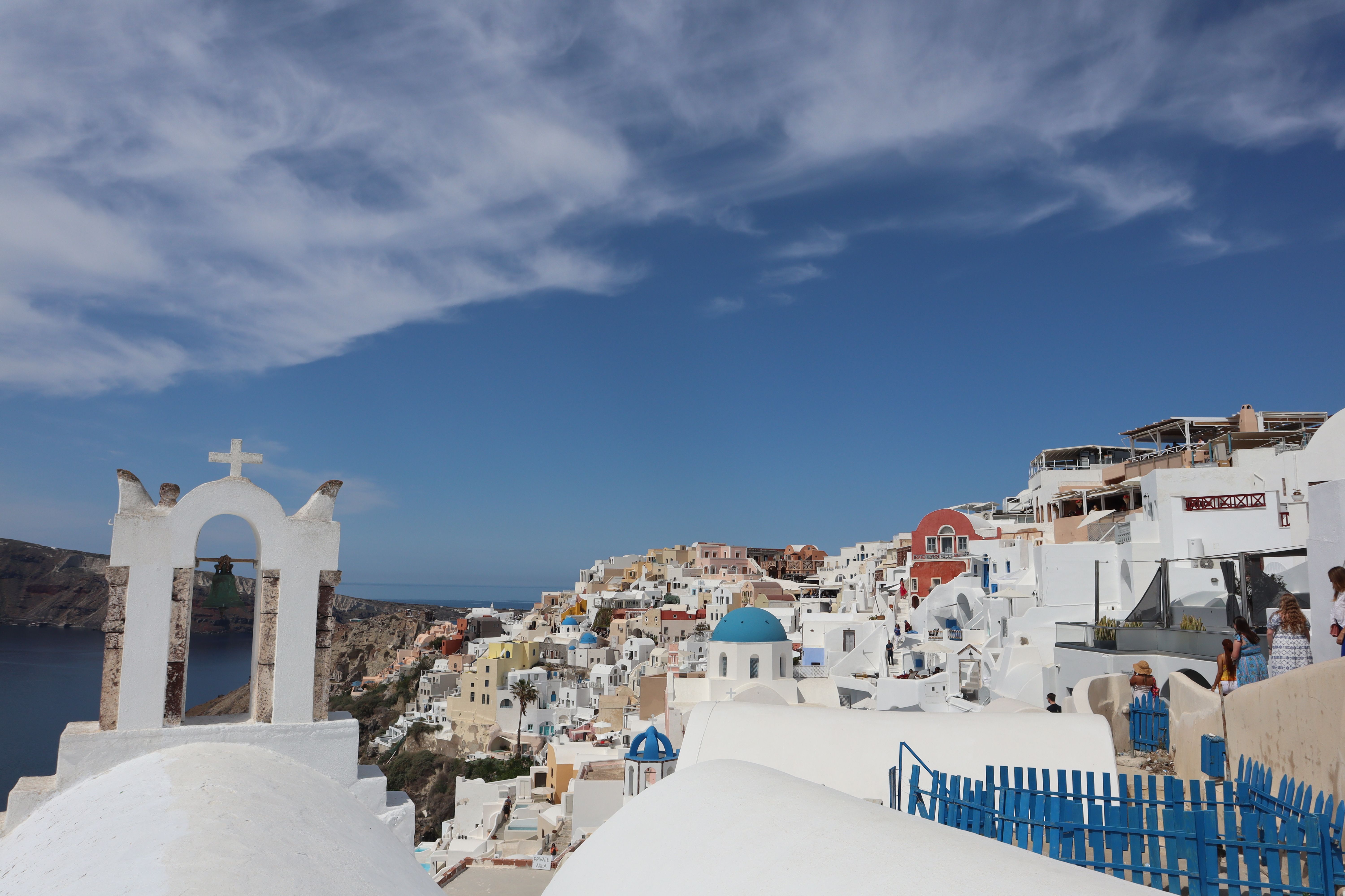 Explore the stunning whitewashed architecture of Fira, Santorini under a clear blue sky.