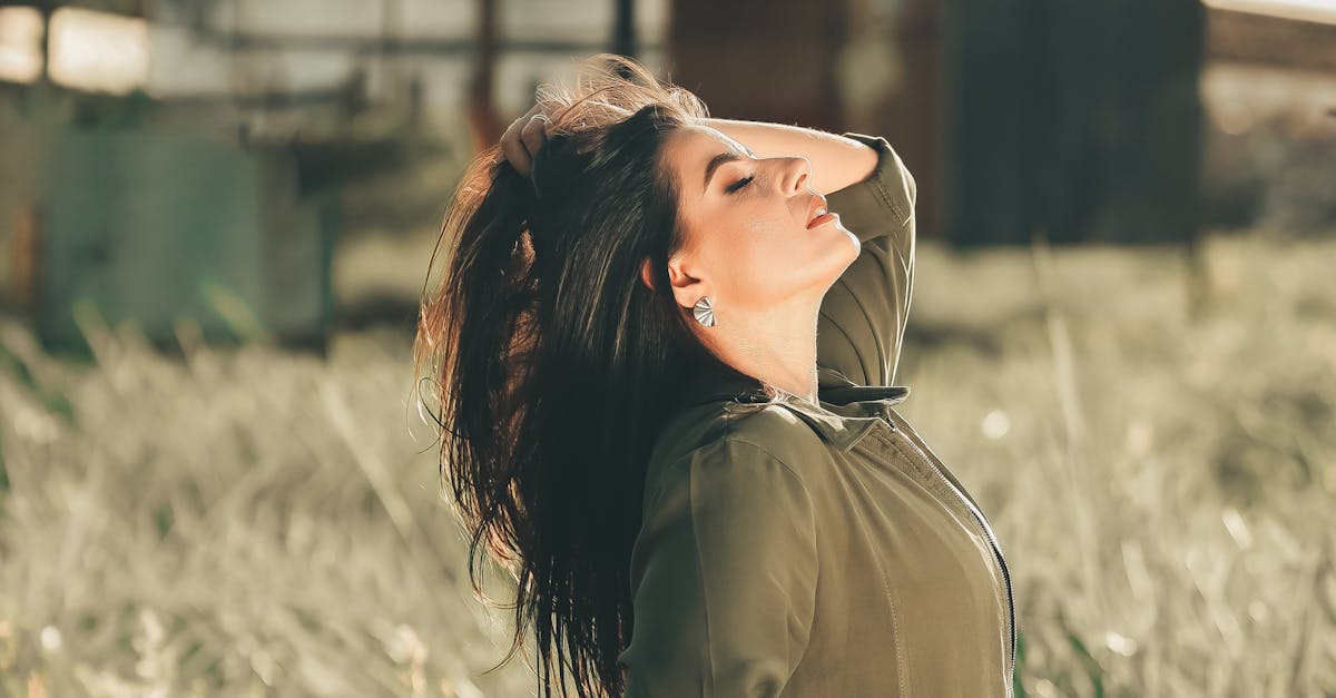 Woman Ruffling her Hair in a Field · Free Stock Photo