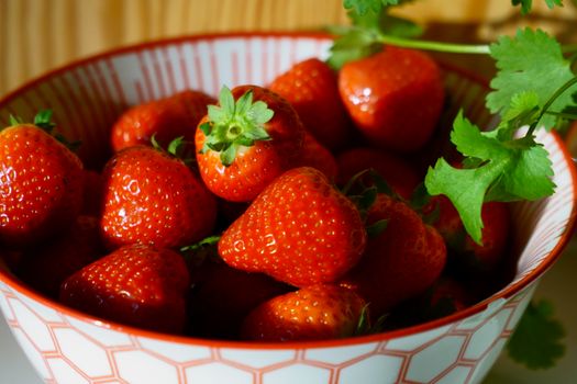 Vibrant fresh strawberries in a decorative bowl, perfect for a healthy lifestyle theme.