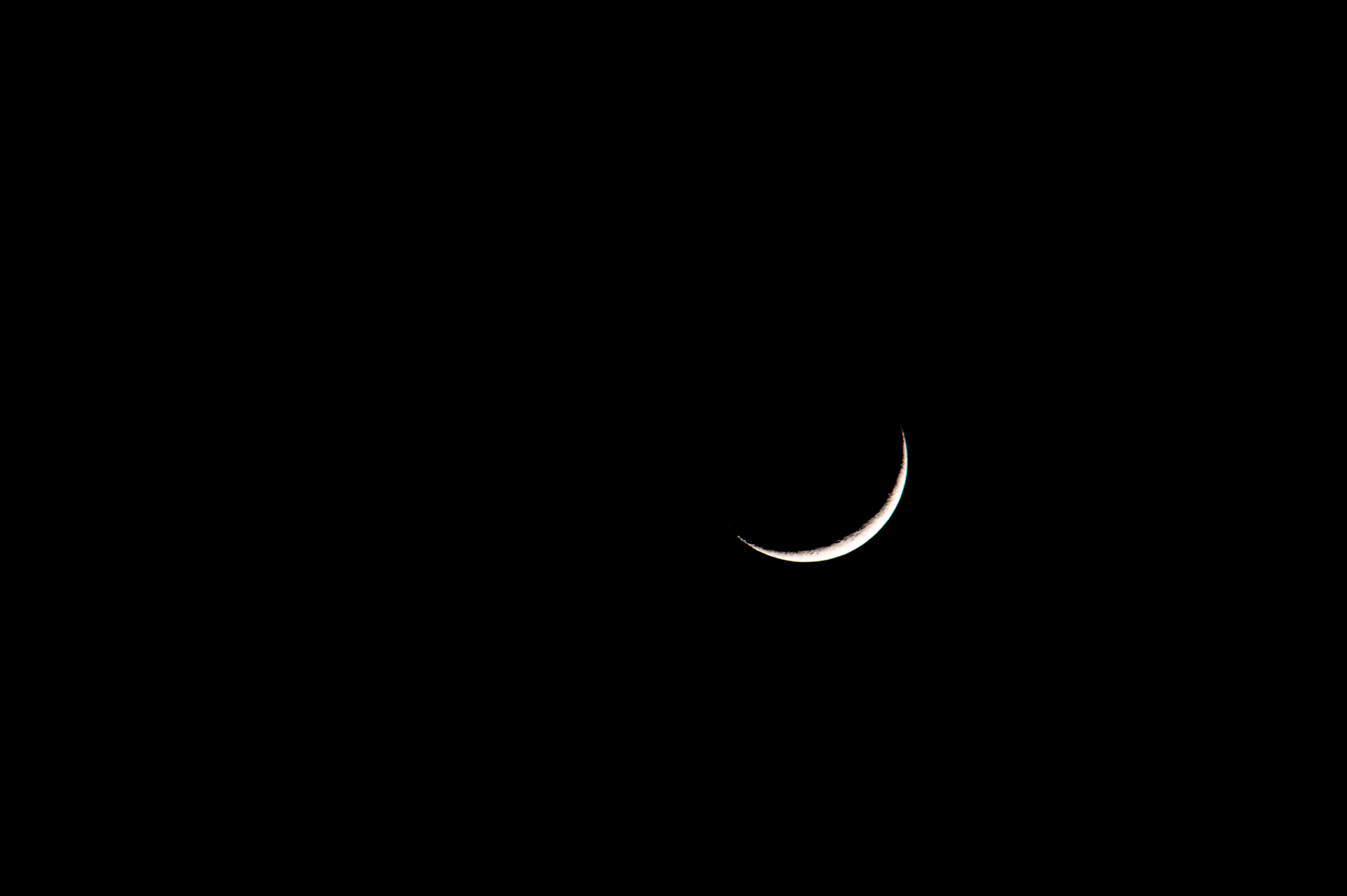 A striking image of a crescent moon set against a deep black sky, showcasing its serene beauty.