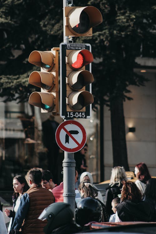 Group of Pedestrians Standing near the Crosswalk and Traffic Light Showing Red Light for the Drivers 