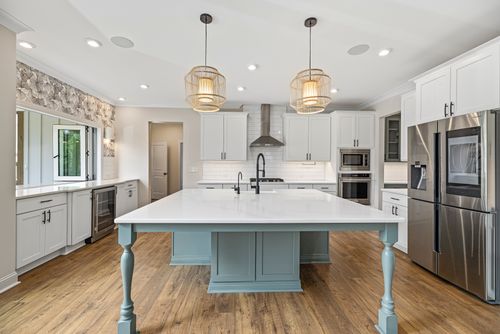 Free Spacious kitchen with white cabinets and modern amenities, featuring a central island. Stock Photo