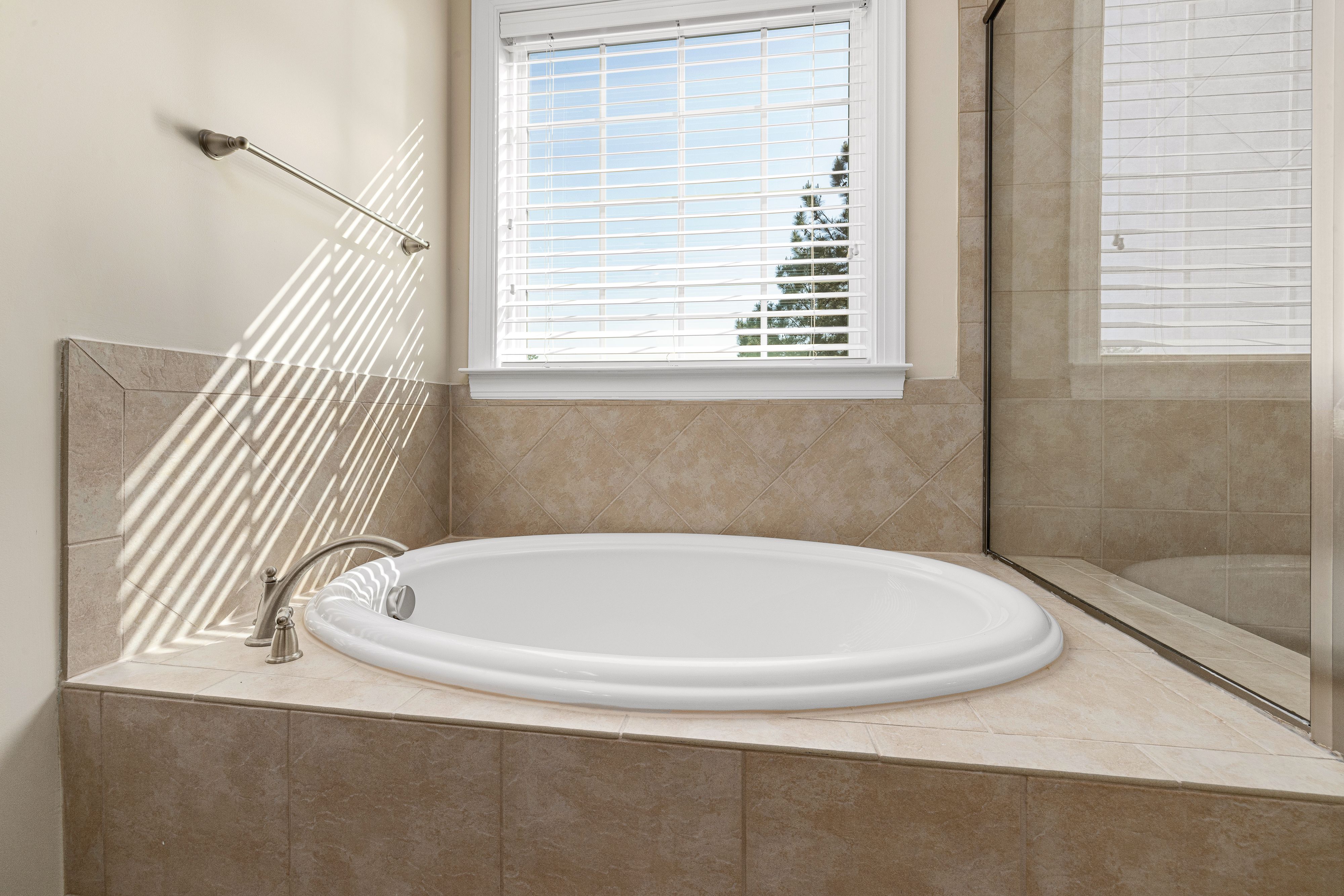 Deep soaking bath set among garden foliage in the private courtyard