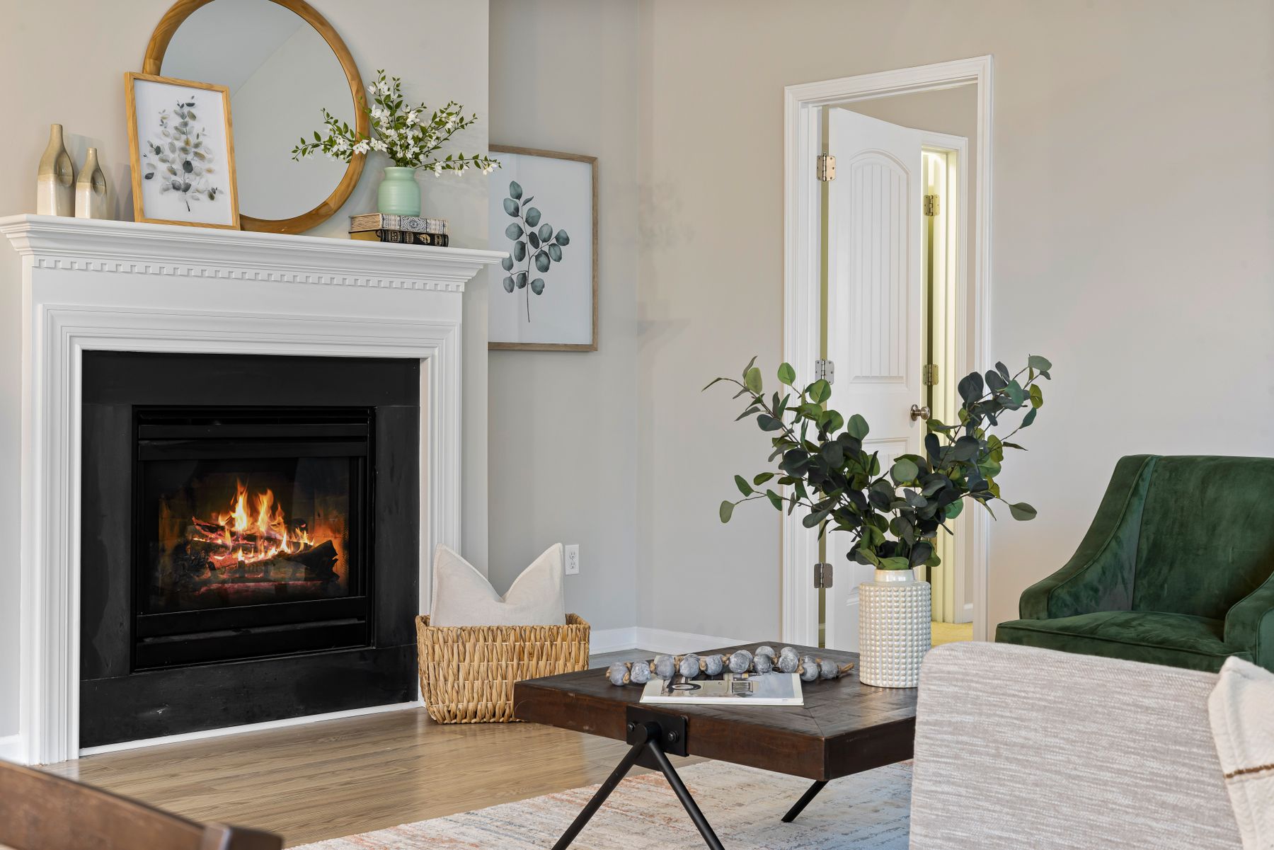 Elegant living room featuring a lit fireplace with mantel and hearth seating