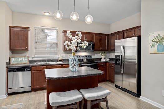 Elegant kitchen featuring stainless steel appliances, wooden cabinets, and a stylish island with seating.