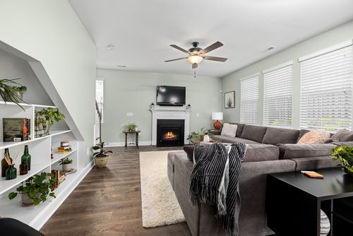 Free Stylish living room featuring a large sectional sofa, fireplace, and indoor plants for a cozy ambiance. Stock Photo