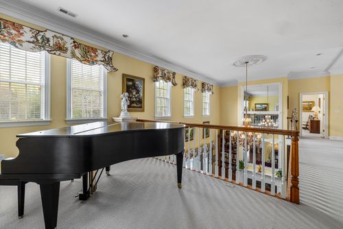 Free Charming interior featuring a grand piano with elegant curtains and ornate railing. Stock Photo