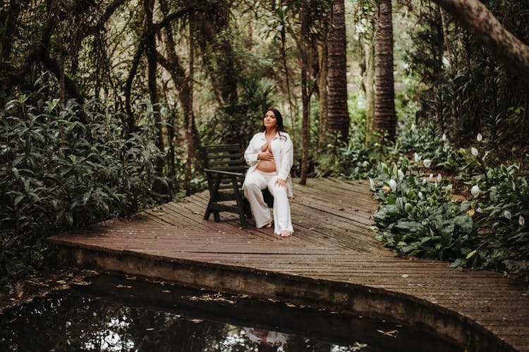 Pregnant Woman Sitting By The Pond 