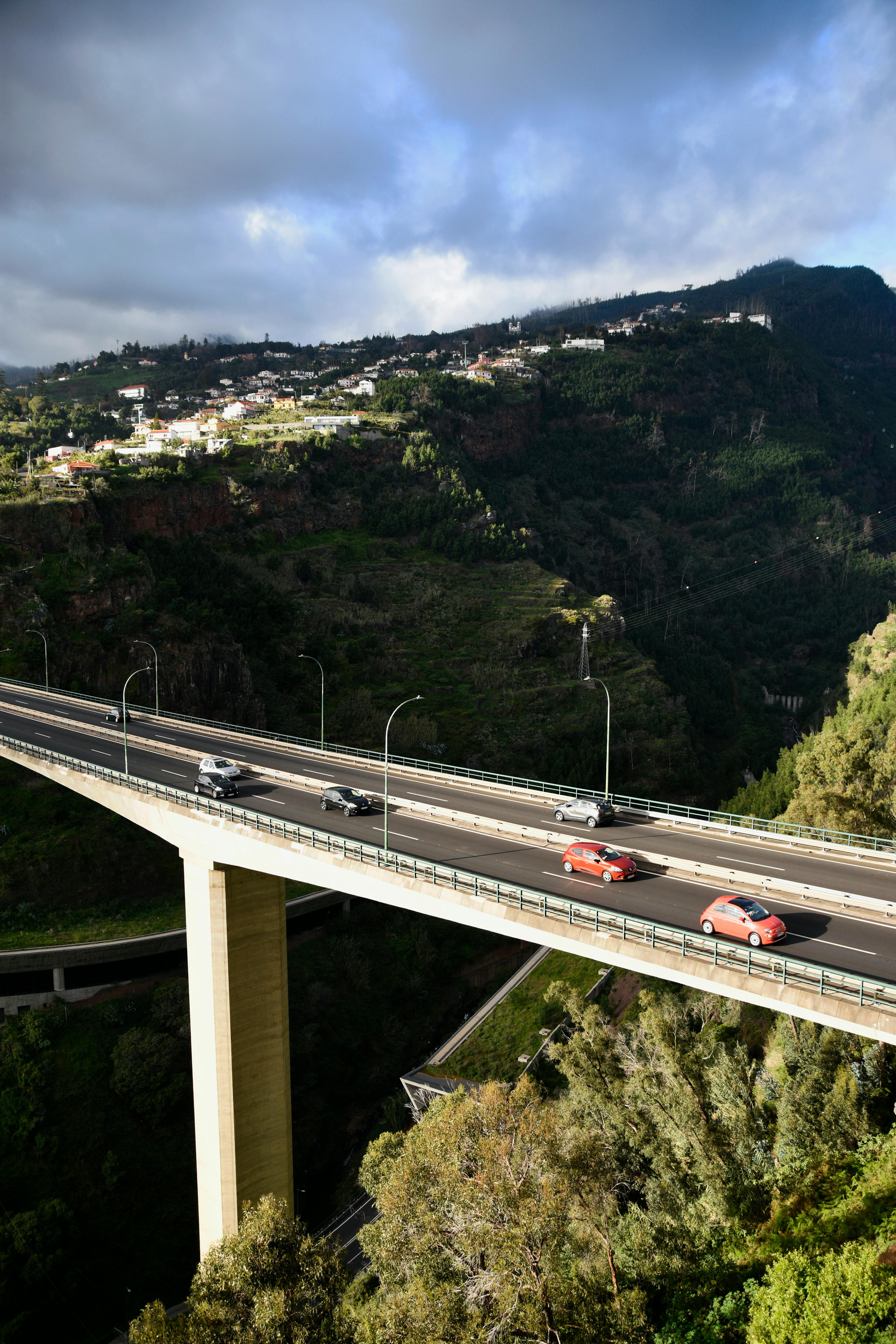 Aerial view of an elevated road with cars in Madeira, Portugal, showcasing stunning landscape.