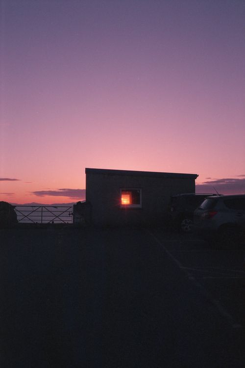 Free Ethereal guardhouse silhouette against a striking purple sunset sky, creating a serene and moody atmosphere. Stock Photo