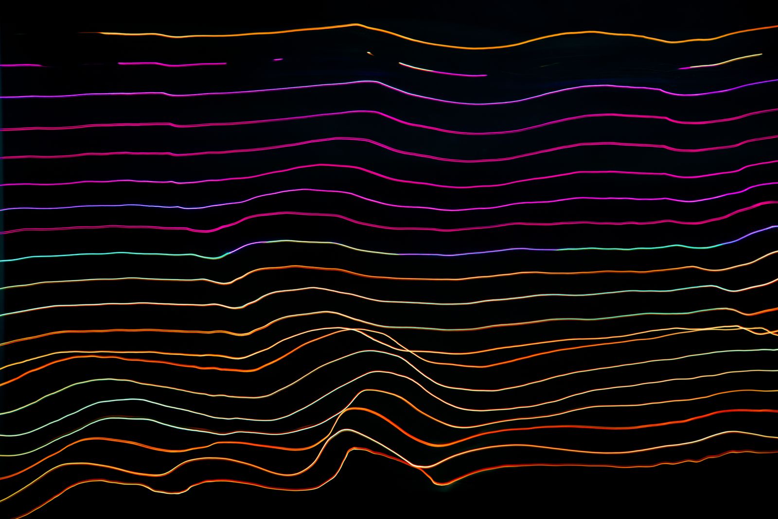 Colorful abstract light trails fanning outward across a dark background