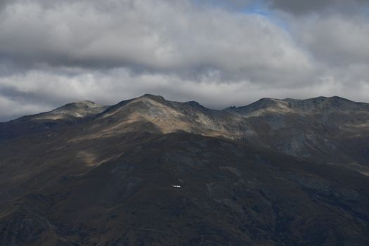 A breathtaking view of a mountainous terrain under a brooding overcast sky.