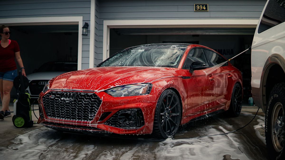 Red car being washed at a garage during a detail