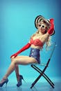一位迷人的女性身着复古时尚，在蓝色椅子上摆着姿势