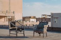 Weathered armchairs on an urban rooftop in Iran, showcasing urban decay.