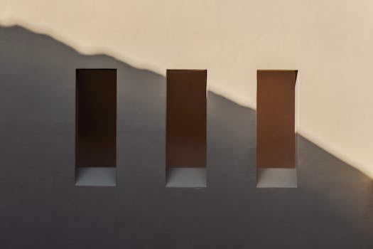 米色墙上，三扇长方形窗户的特写镜头投下阴影