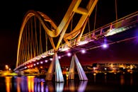 未来派的灯光桥梁倒映在平静的河流上，构成美丽的夜间景观