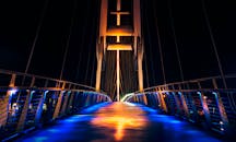 现代照明桥在夜景中充满活力，五颜六色的灯光与倒影交相辉映