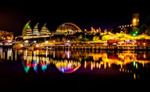 平静的河面上，灯火通明的建筑倒映出令人惊叹的都市夜景