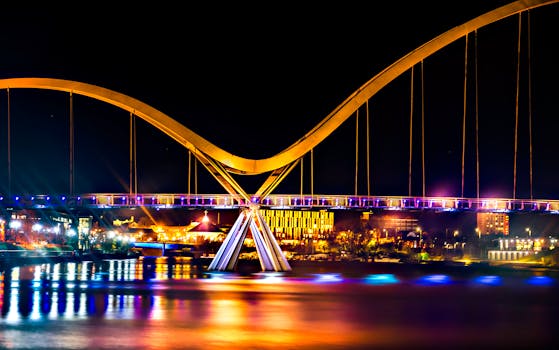 现代拱桥的夜景令人惊叹，城市灯光倒映在水面上