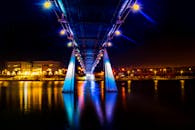 在壮丽的夜色中，一座明亮的桥梁将鲜艳的色彩反射到下方平静的河流上