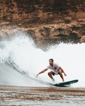 A surfer expertly riding a large wave on a sunny day at the beach.