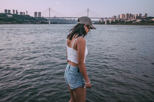 Girl Dressed in Denim Shorts Standing by the Water 