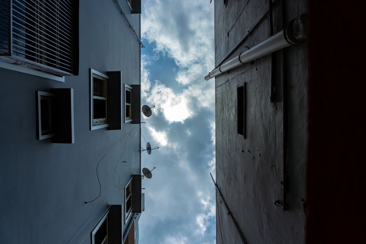 upward city view captures symmetrical building facades and a cloudy sk