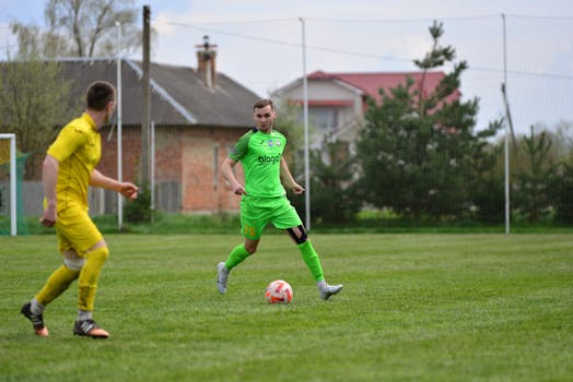 Two soccer players in action during an outdoor game on a grassy field.