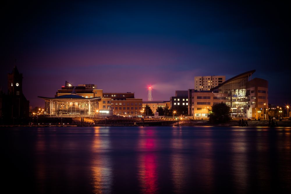 Stunning view of Cardiff Bay's illuminated skyline at night reflecting on the water.