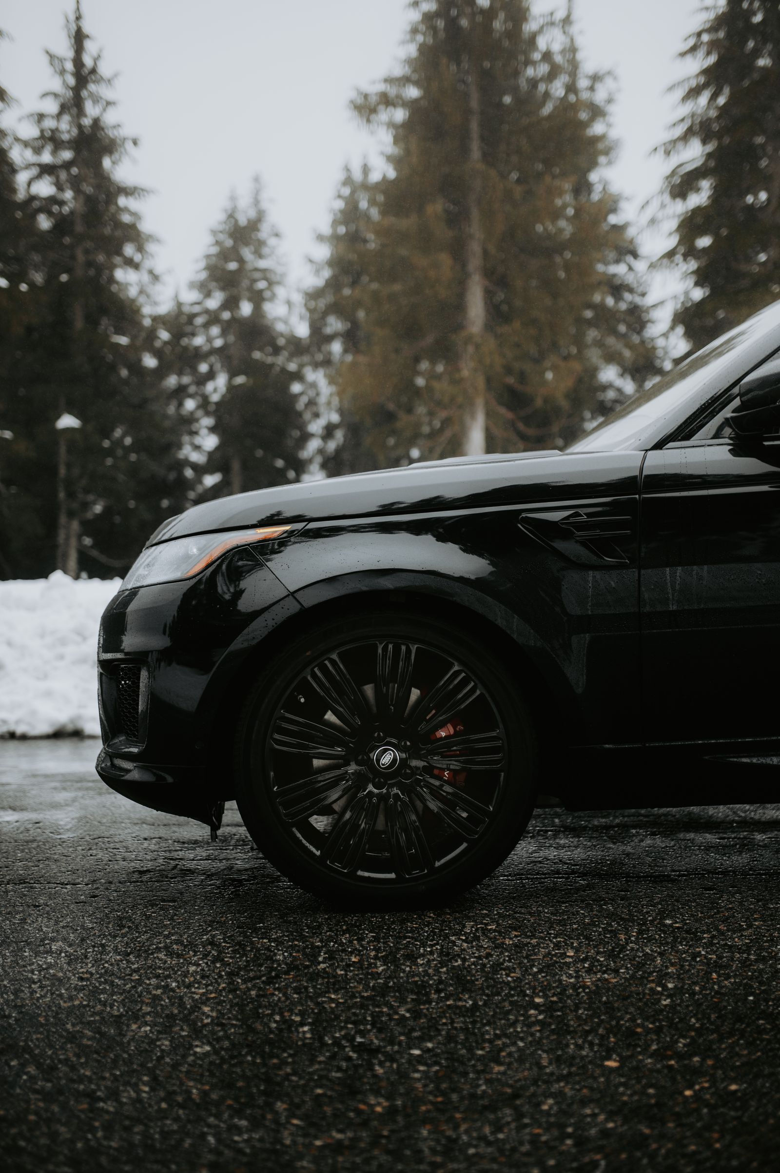 Close-up of a dark SUV front fender and wheel