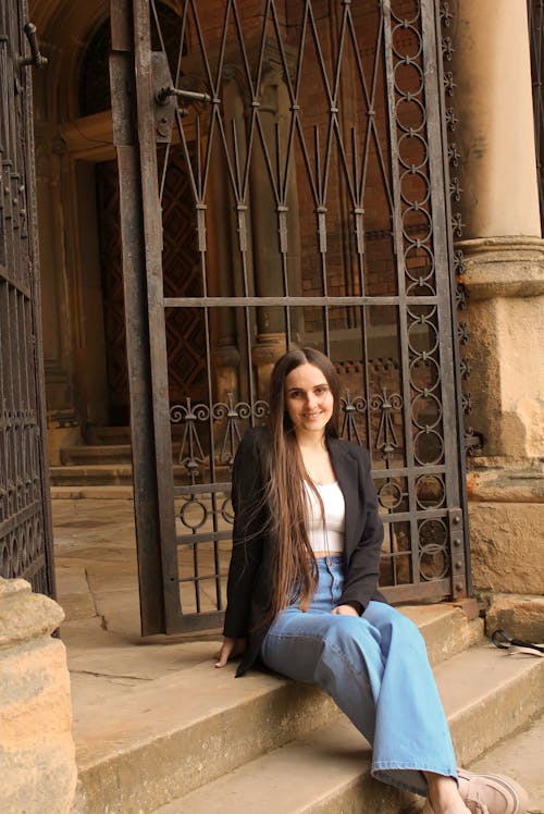 Young Woman Sitting on the Steps of a Building