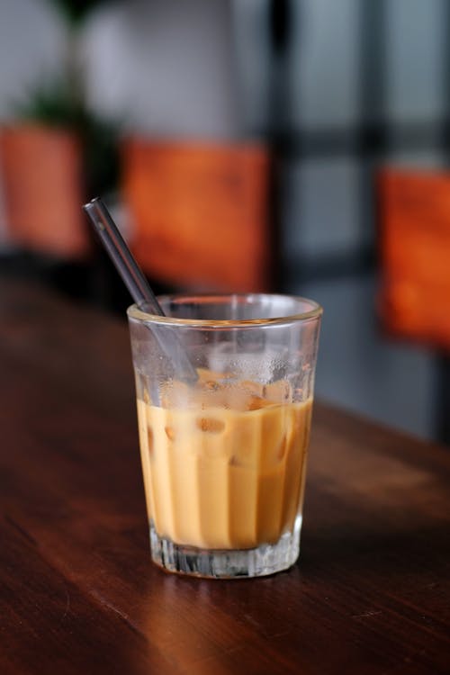 Free Glass of Cold Coffee Drink on a Brown Wooden Table Stock Photo