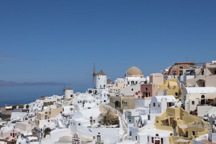 Aerial view of white houses and blue domes in Oia, Santorini