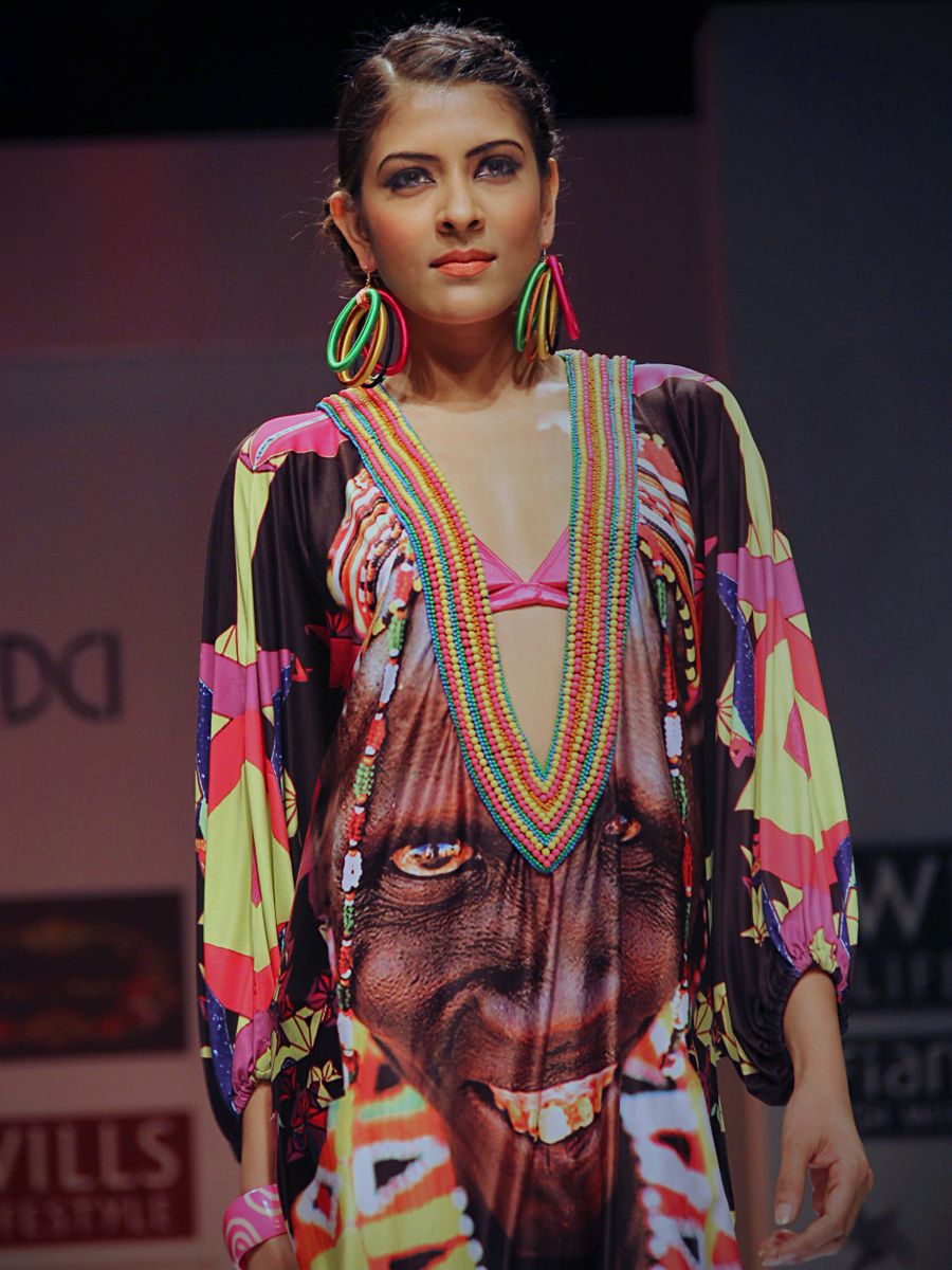 Model in leuchtendem Kleid auf dem Laufsteg