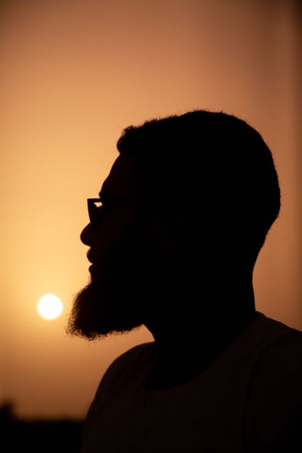 Silhouette of a man in profile against a warm glow — photo by Moaz Tobok on Pexels