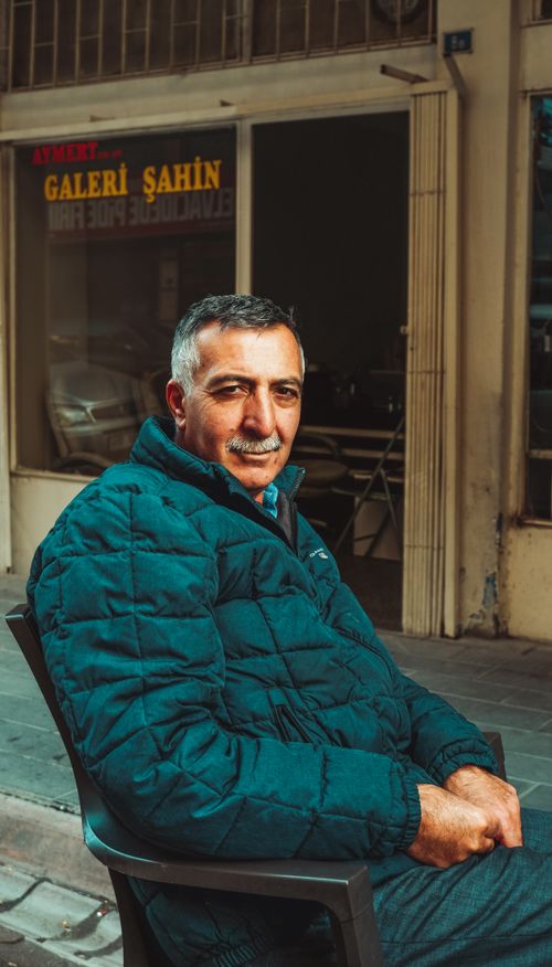 Free Portrait of an elderly man sitting outdoors in Turkey, exuding warmth and friendliness. Stock Photo