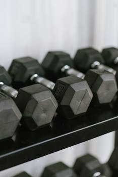 Close-up of hex dumbbells neatly arranged on a rack in a gym, perfect for fitness themes.