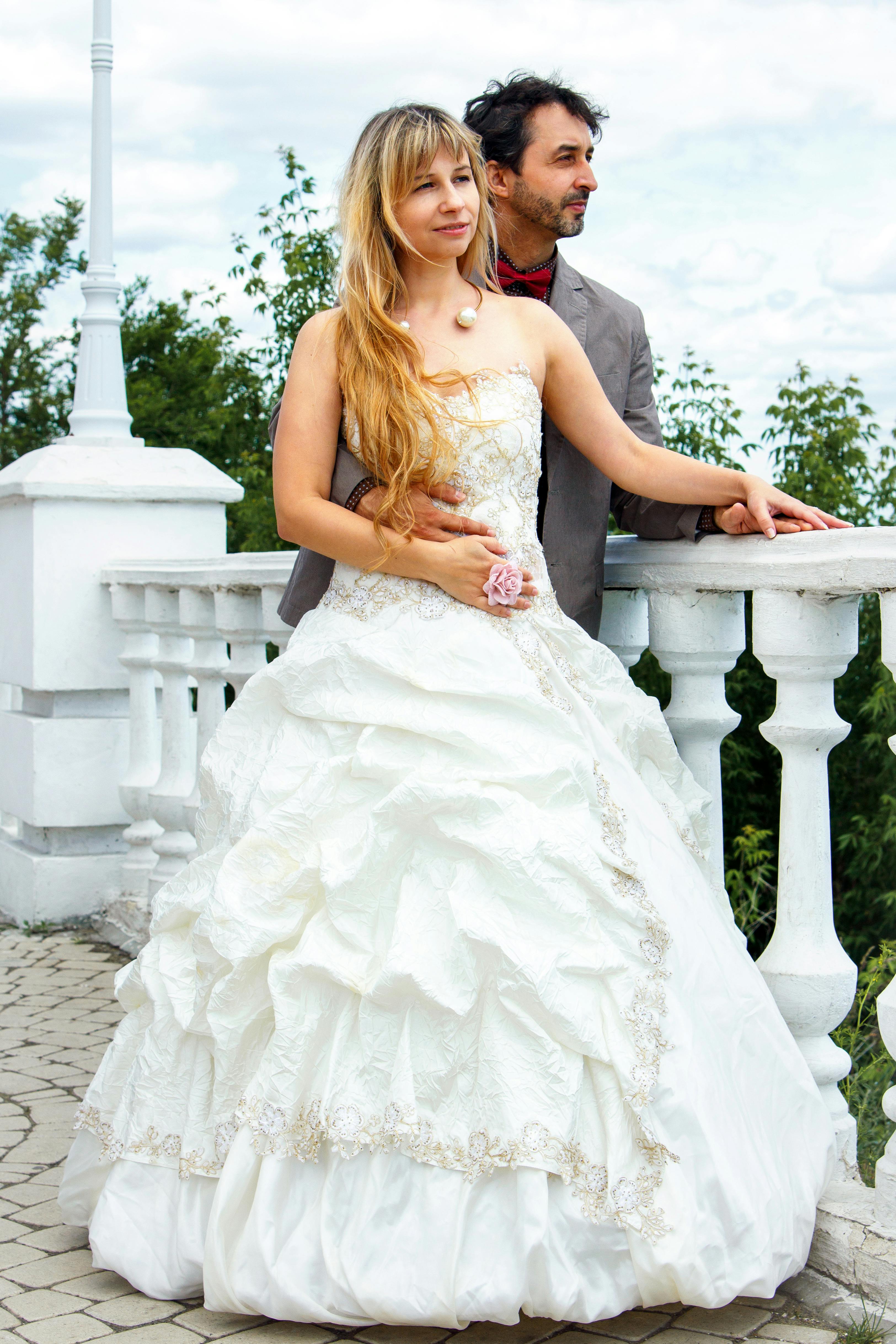 Woman Wearing Pink Wedding Gown Standing Next to Man 