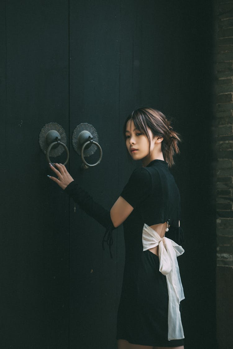 Young Woman In Dress Posing Near Old Doors