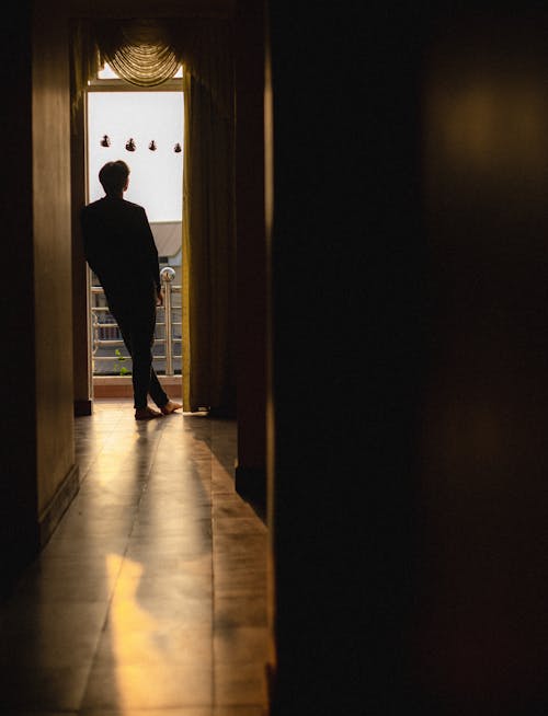 Silhouette of Person Standing in Entrance to Corridor