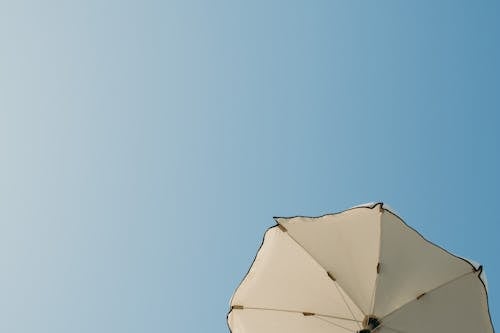 Low Angle Shot of a White Umbrella under a Clear, Blue Sky 