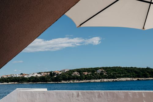 Free Stunning coastal view with sunshade, capturing summer vibes and seaside tranquility. Stock Photo