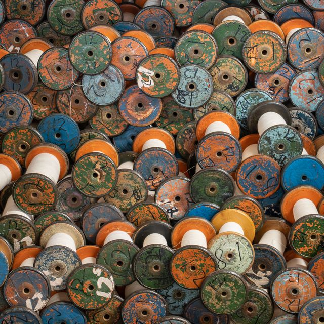 A pile of painted wooden thread spools — photo by T6 Adventures on Pexels