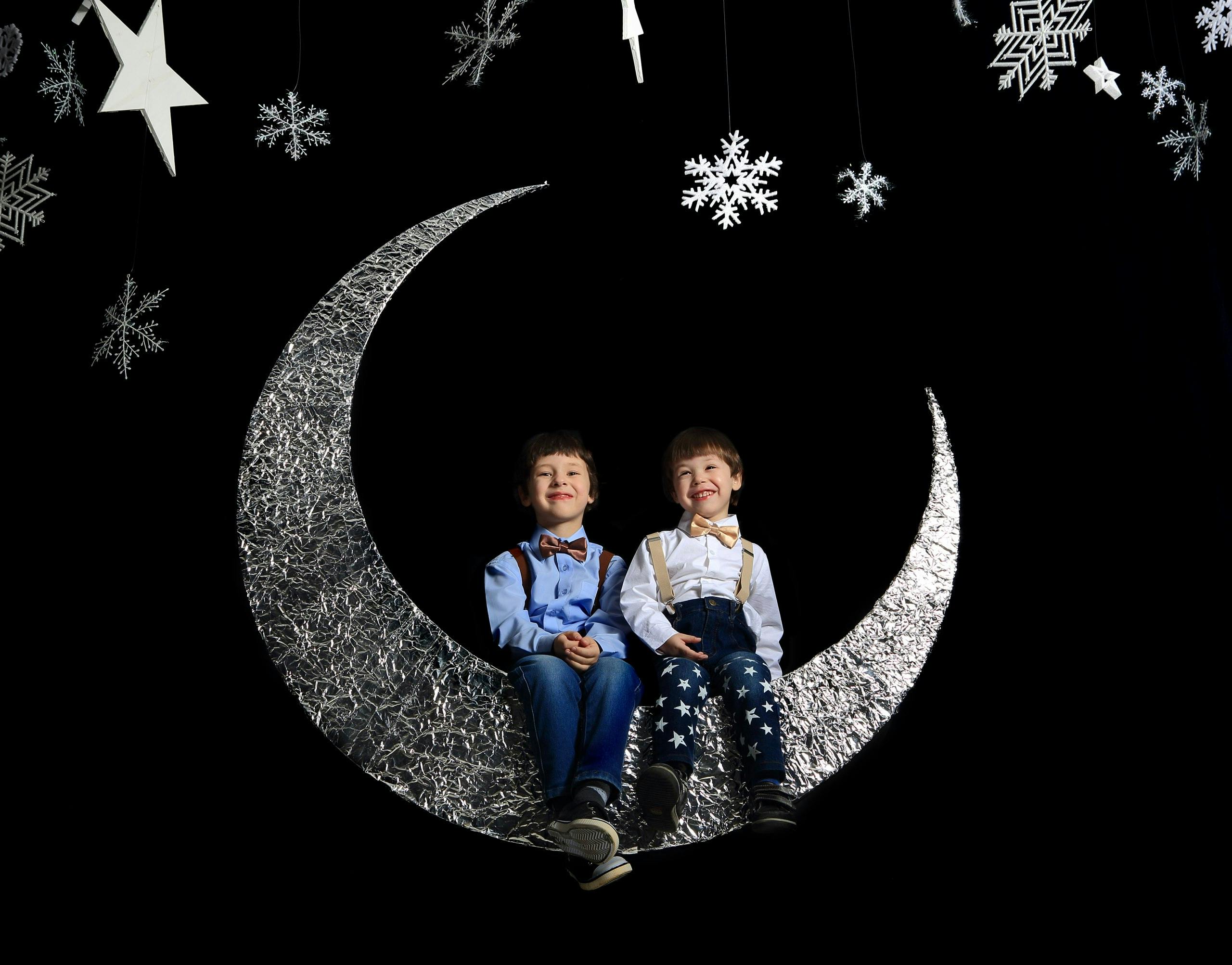 Twins sitting on crescent moon | Photo: Pexels