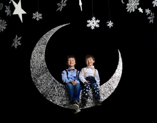 Two Boys Sitting on Crescent Moon