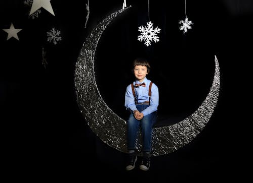 Boy Sitting on Moon Decor