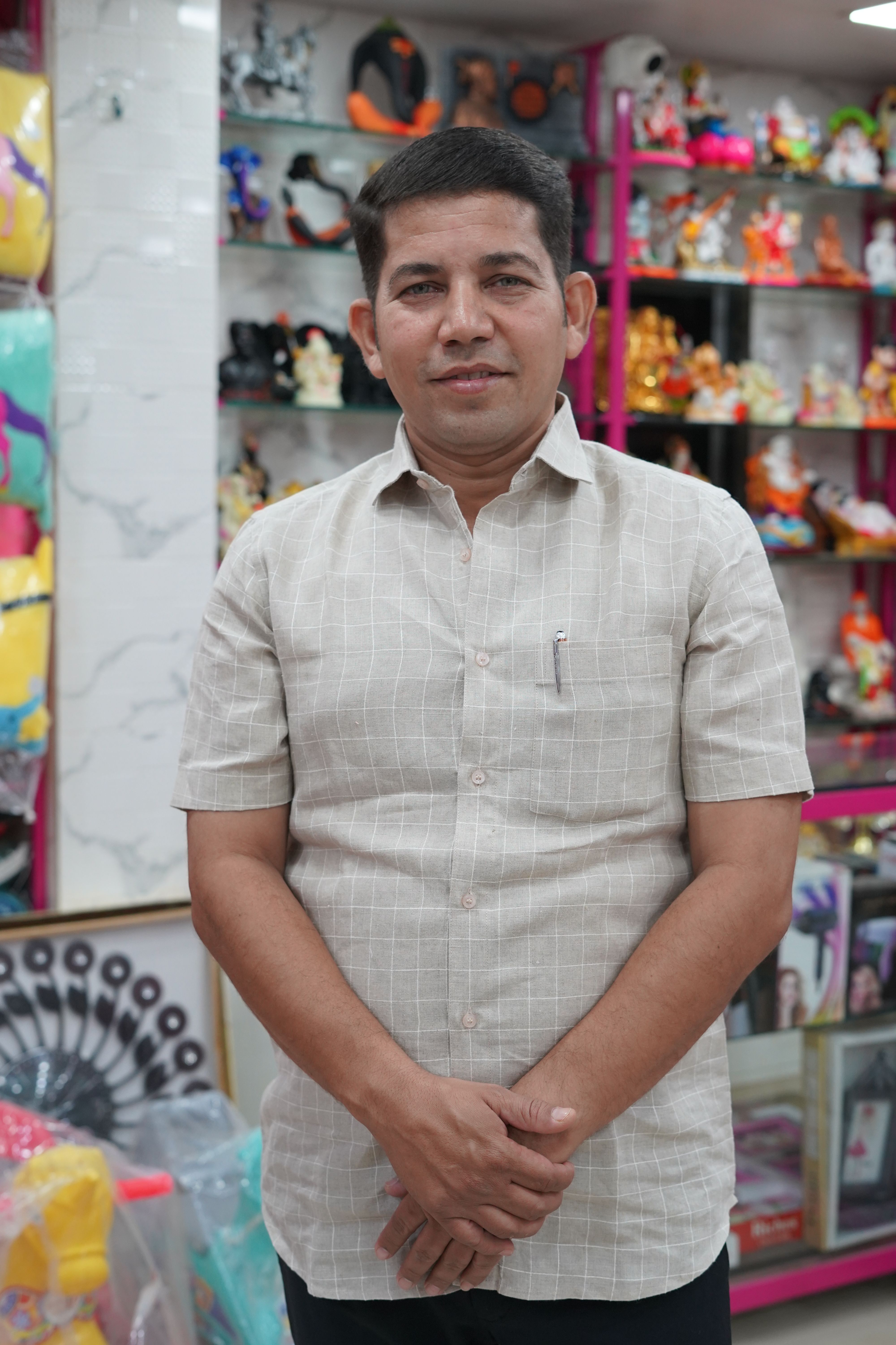Man posing in a toy store surrounded by colorful shelves of toys