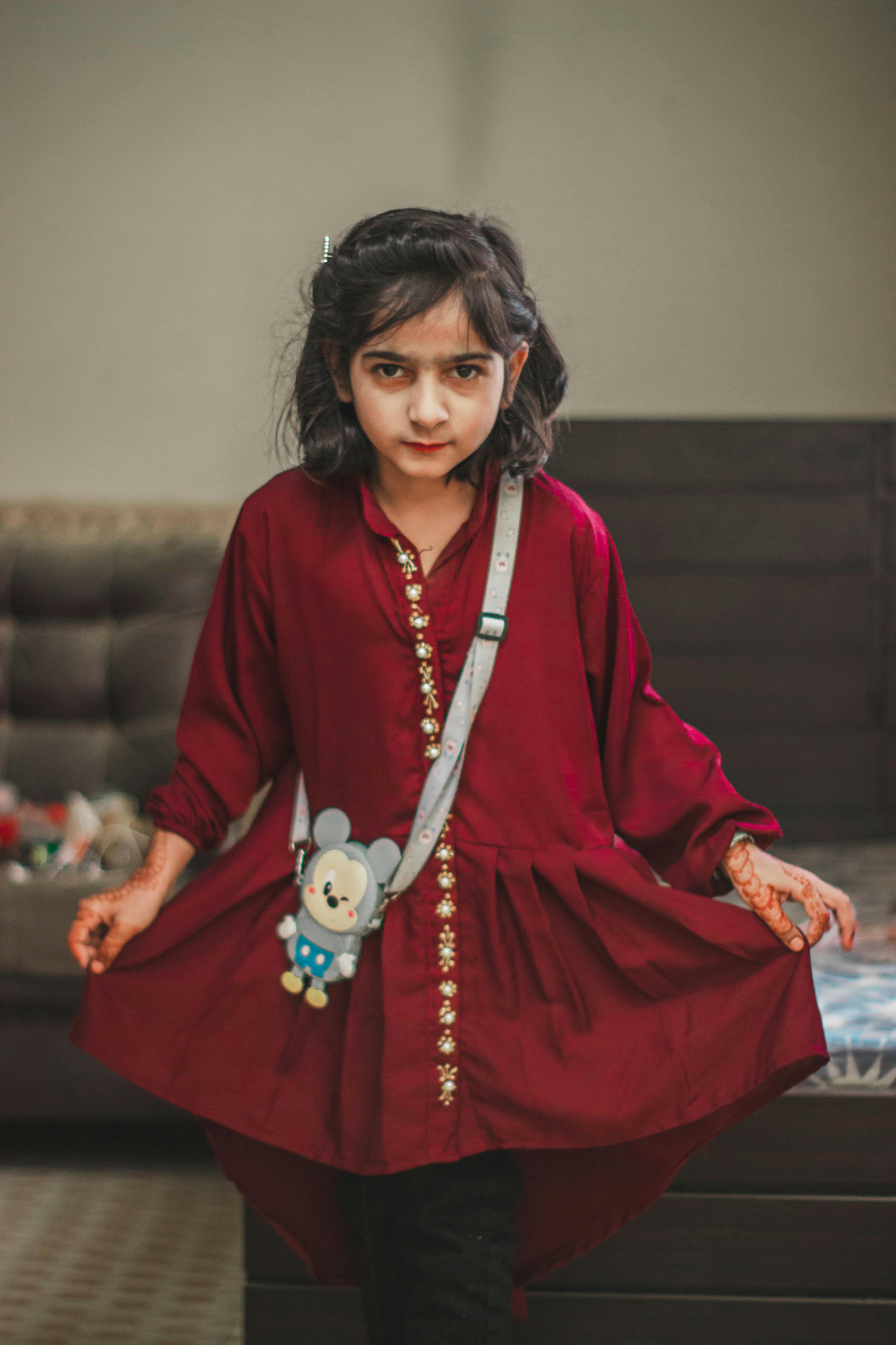 a girl in a traditional dress and henna tattoos on hands