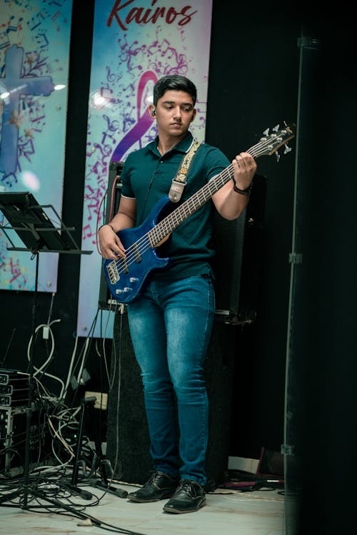 Young Man Playing an Electric Guitar in a Band on the Stage 